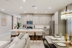 Discover a stylish kitchen with sleek cabinetry and a spacious island, ideal for casual dining and meal prep. The elegant chandelier adds a warm glow, creating an inviting space for shared culinary experiences.
