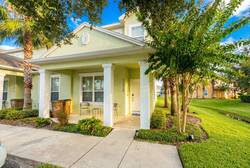 Step onto the charming porch framed by lush greenery, where you can enjoy your morning coffee in the sunlight. With elegant white columns and a clean, inviting walkway, this entryway sets the tone for a delightful stay.