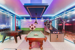 Experience our lively game room with a classic pool table and foosball table, both glowing under dynamic LED lights. The energetic, sports-themed decor sets the stage for unforgettable nights with family and friends.