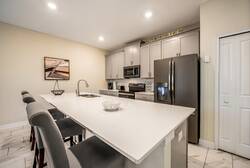 Enjoy our sleek kitchen with a spacious white island perfect for casual dining and stylish gray bar stools. Modern appliances and soft lighting create a bright space ideal for meal prep or savoring your morning coffee.