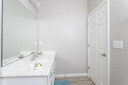 Step into a bright bathroom featuring a spacious white vanity complemented by a large mirror, enhancing the airy feel of the room. Soft blue accents add a touch of color, while sleek fixtures promise both style and functionality.