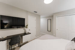 This cozy bedroom offers a plush bed with soft linens for a restful stay. A sleek desk and chair create an ideal workspace, while the large television invites you to unwind and relax after a day of adventure.