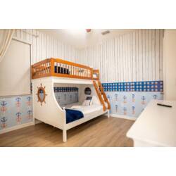 English, US:
Rest in a playful nautical-themed bedroom with a charming ship-style bunk bed, anchor wallpaper, blue accents, and warm wood floors. Soft bedding and fun details create a cozy space for kids to enjoy during vacation.