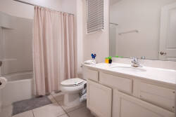Refresh in a bright bathroom with a spacious vanity, large mirror, shower and tub combo, and soft neutral tones. Good lighting, practical amenities, and clean finishes create a comfortable space for your vacation.