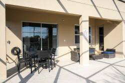Step outside to a spacious patio with sleek black furniture, ideal for al fresco dining or soaking up the sun. The screened enclosure creates a seamless connection to nature while ensuring your comfort and relaxation.