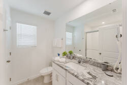 This bright bathroom boasts sleek white cabinetry and beautiful granite countertops for a touch of luxury. Natural light streams in, creating a fresh ambiance that's perfect for unwinding after a day of adventure.