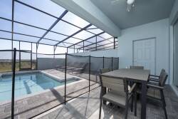 Step outside to discover this screened patio, featuring a stylish dining set and a private pool just steps away. The light blue walls and expansive view create a bright, airy atmosphere perfect for relaxing or entertaining.
