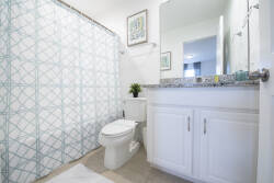 Bright and airy, this bathroom features a calming blue and white patterned shower curtain that complements the sleek granite countertop. With modern fixtures and thoughtful decor, it’s a refreshing space for your daily routines.