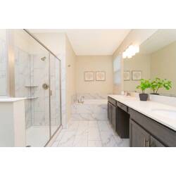 Refresh in a bright bathroom with a glass shower, soaking tub, double vanity, large mirror, marble-style tile, soft lighting, and clean modern finishes.