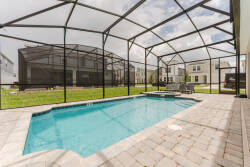 Discover your private oasis with a sparkling pool nestled in a spacious screened enclosure for year-round enjoyment. The sunlit patio, adorned with elegant brick pavers and cozy seating, invites you to relax under the open sky.