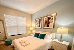 Unwind in this cozy bedroom with soft beige walls and plush carpeting. A large window lets in natural light, while tasteful artwork and a comfy bed with crisp linens set the mood for peaceful, restful nights.