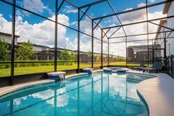 Step outside to discover your own private oasis, featuring a sparkling pool surrounded by a stylish screened enclosure. Relax on the sleek loungers or enjoy the view of the lush green landscape, all bathed in natural light.