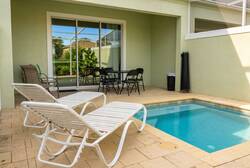 Step outside to your private oasis, complete with a refreshing plunge pool for a quick dip. Unwind on sleek white lounge chairs or savor al fresco dining at the stylish outdoor table surrounded by a tranquil green backdrop.