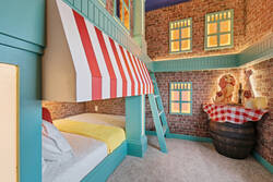 Rest in a playful themed bedroom with a cozy bunk bed, brick-style walls, striped awning, warm window lights, soft carpet, and charming dining-inspired decor, creating a fun space for kids during vacation.