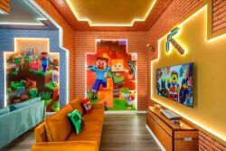 Step into a vibrant gaming paradise adorned with playful Minecraft murals and dynamic LED lighting, perfect for family fun. The cozy orange sofa invites you to relax while enjoying a movie night on the wall-mounted TV.