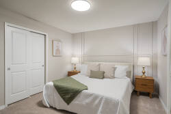 Relax in a cozy neutral bedroom with a comfortable bed, soft curtains, warm bedside lamps, wood nightstands, and simple decor, creating a peaceful space for vacation rest.
