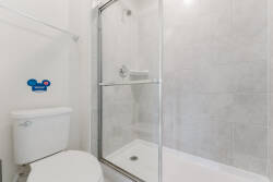 Step into this bright bathroom featuring sleek, modern tiles that reflect light beautifully, creating a clean and fresh atmosphere. The spacious walk-in shower offers both style and comfort, making your daily routines a pleasure.
