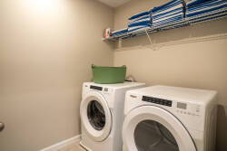 This practical laundry area features sleek, modern appliances that make cleanup effortless after your adventures. With neatly stacked linens above, you'll appreciate the thoughtful organization that enhances your stay.