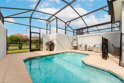 Relax in a private screened pool area with sparkling water, outdoor seating, hanging chair, BBQ grill, and open sky views, perfect for swimming and family moments during vacation.