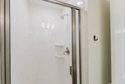 Step into a bright and clean shower space featuring sleek glass doors that enhance the airy feel. The crisp white walls create a refreshing atmosphere, perfect for unwinding after a day of adventures.