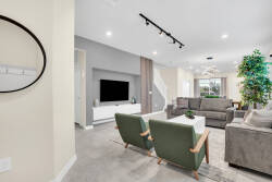 Welcome to a bright living area featuring inviting sofas and modern decor. Enjoy the sleek TV console and large windows that flood the space with natural light, making it the perfect airy retreat after your adventures.