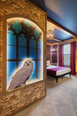 Step into a whimsical bedroom where a stunning owl mural greets you, framed by textured stone walls that add a rustic charm. The deep purple accents of the bedding and curtains create a cozy atmosphere, perfect for restful nights.