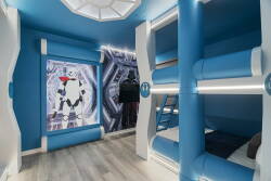 Welcome to this lively bunk room, featuring playful blue walls and modern decor that appeal to all ages. Enjoy the sleek, built-in bunks and eye-catching mural, making it a perfect spot to relax after your adventures.