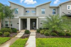Enter a warm and inviting space surrounded by lush greenery and vibrant landscaping, where modern architecture offers a welcoming first impression. The soft exterior hues enhance a tranquil atmosphere, perfect for a relaxing stay.