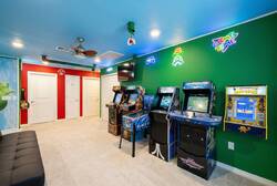 Enjoy a colorful Super Mario game room with arcade machines, neon signs, a cozy sofa, wall-mounted TV, ceiling fan, and playful decor, perfect for family fun during vacation.