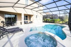 Step outside to find your private oasis with a sparkling pool and relaxing hot tub, all within a sleek screened enclosure. Lounge chairs invite you to soak up the sun and enjoy the lush surroundings.