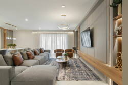 Relax in a beautifully designed living area that combines comfort and style, featuring a spacious grey sectional with cozy pillows.