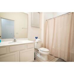 Refresh in a bright bathroom with a spacious vanity, large mirror, shower and tub combo, and soft neutral tones. Good lighting, practical amenities, and clean finishes create a comfortable space for your vacation.