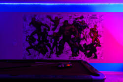 Enjoy a lively game room with a sleek pool table, vibrant LED lighting, and a bold comic mural that creates a fun atmosphere, making it the ideal spot for relaxation and entertainment with friends or family.