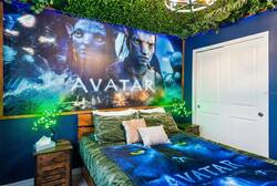 Rest in an Avatar themed bedroom with a cozy bed, blue walls, leafy ceiling, glowing lights, bold wall art, and bow-and-arrow decor, creating a fun space for vacation.