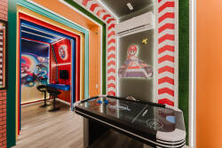 Experience a lively entertainment area with vibrant walls and a glossy air hockey table, ideal for friendly competition. The colorful decor and bright lighting invite guests to relax and have fun in a cheerful atmosphere.