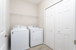 This laundry area, equipped with sleek white appliances, makes it easy to keep your vacation wardrobe fresh. Ample shelving provides practical storage, ensuring all your essentials are organized and ready for your adventures.