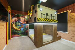Welcome to this playful bedroom, featuring a unique custom bunk bed that sparks imagination. A vibrant mural of a classic video game character adds fun, while warm wood accents create a cozy atmosphere for your stay.