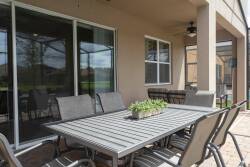 Step outside to a spacious patio where a sleek metal dining set invites al fresco meals. Enjoy the fresh air while surrounded by lush greenery, and let the natural light fill your gatherings with warmth and comfort.
