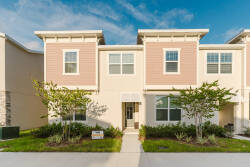 Step inside this charming vacation home, where soft pink accents contrast beautifully with the lush greenery outside. Large windows flood the space with natural light, creating a warm and welcoming ambiance throughout.