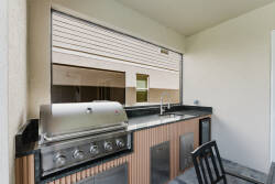 Step outside to a stylish outdoor kitchen with stainless steel appliances and a sleek black countertop, perfect for al fresco dining. The open design lets you enjoy meals while soaking in the fresh air.