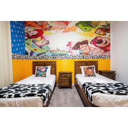 Rest in a colorful Toy Story themed bedroom with two cozy beds, playful character mural, wood furniture, and fun cow-print blankets. Bright colors, soft carpet, and cheerful details create a fun space for kids during vacation.