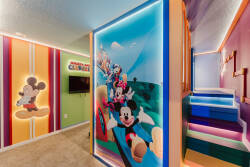 Immerse yourself in a lively space filled with colorful walls featuring playful Mickey Mouse graphics. The cozy carpet and whimsical lighting make it an ideal spot for kids to relax and play after a fun-filled day of adventure.
