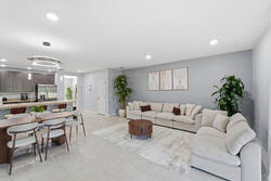 Gather in a bright open living and dining area with a cozy sectional sofa, wood dining table, modern lighting, greenery, and a nearby kitchen, creating a comfortable space for your vacation.