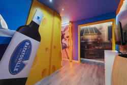 Step into a vibrant atmosphere where playful artwork and bright colors energize your stay. The creative decor features a whimsical cheese backdrop and a charming bottle display, setting a unique tone for your vacation.