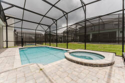 Step outside to enjoy your private pool area, featuring a sparkling blue pool and a cozy spa, all framed by a sleek screened enclosure. The elegant stone patio provides the perfect place to soak up the sun or relax in the shade.