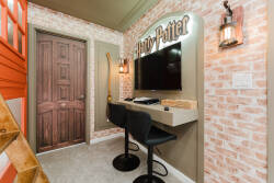 Discover a whimsical workspace featuring charming brick wallpaper and a playful Harry Potter theme. With a sleek desk and stylish black bar stools, it’s the perfect cozy spot for planning adventures or relaxing after a fun day.