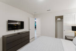 Welcome to this cozy bedroom with a plush bed and a stylish dark wood dresser for a sophisticated touch. Soft, neutral walls create a calming vibe, and a flat-screen TV provides entertainment for your relaxing evenings.