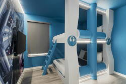 Discover a vibrant haven designed for fun, showcasing a striking blue palette and unique bunk beds for all ages. Playful decor and cozy textures blend to create an energizing space perfect for relaxation and play.
