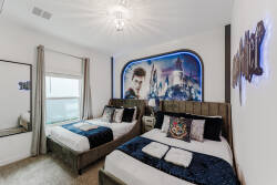 Experience a whimsical bedroom with two cozy, upholstered beds dressed in vibrant textiles. An enchanting wall mural adds adventure, while a shimmering chandelier casts a warm glow, creating a delightful atmosphere just for you.