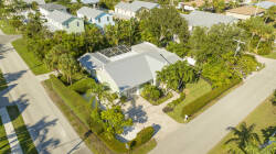 This charming home has a lovely pale blue exterior surrounded by lush greenery, inviting you to enjoy the tranquil atmosphere. The well-kept landscaping and spacious courtyard make it perfect for relaxation and leisure.